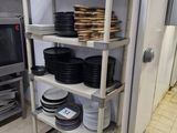 de nombreuses assiettes et casseroles empilées sur une étagère dans la cuisine