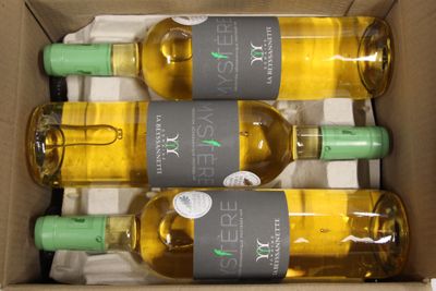 four bottles of white wine in a cardboard box on a table