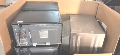 deux micro-ondes dans un carton, avec un autre carton posé par terre