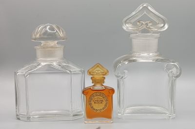two bottles of perfume sitting next to each other on a table