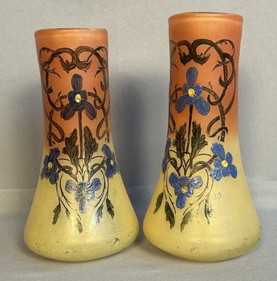 deux vases décorés de fleurs, posés sur une table