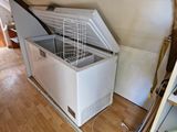 a white chest freezer sitting in the corner of a room