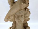 marble bust of a woman wearing a hat with a bird on top of it