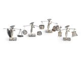 plusieurs figurines en argent représentant des femmes avec des parapluies et d'autres objets