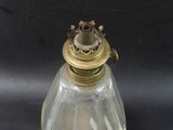 an antique brass and glass oil lamp on a black background