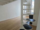 a room with wooden floors and white walls and a spiral staircase