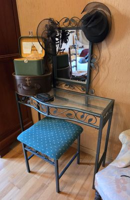a small desk with a chair and a mirror