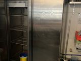 a stainless steel refrigerator in a kitchen next to a counter