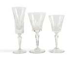 three clear wine glasses sitting next to each other on a white surface