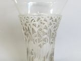 un vase en verre orné d'un motif sur un fond blanc