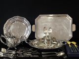 un plateau en argent et des couverts en argent posés sur une table noire