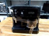 une cafetière noire posée sur une table en bois