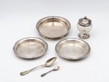 a group of silverplated dishes and spoons on a white surface