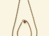 a close up of a necklace and a bracelet on a white background