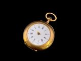 une image d'une montre de poche en or avec des chiffres romains sur le cadran