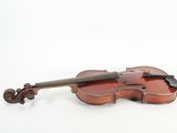 an old violin sitting on top of a white surface