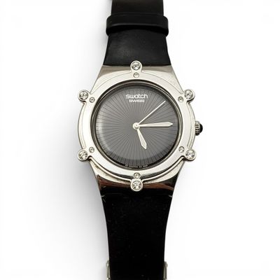 une image d'un gros plan d'une montre-bracelet sur une surface blanche