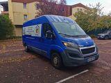 a blue van parked in a parking lot next to a building