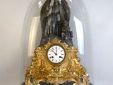 a clock under a glass dome with an angel on it