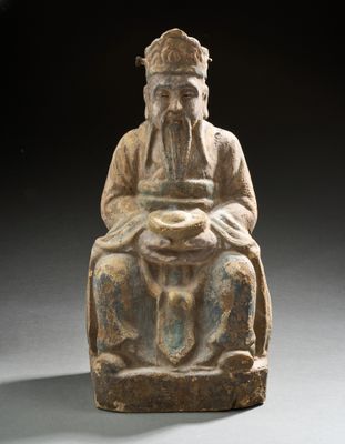 une vieille statue représentant un homme assis sur une chaise, tenant un bol
