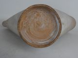 a white vase with a brown rim sitting on a table