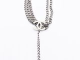 a chanel necklace with a silver chain and a chanel charm