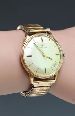 an image of a gold wrist watch on a woman ' s arm