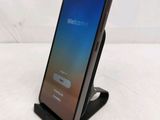 a close up of a cell phone on a stand with a welcome screen