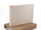 a white book sitting on top of a wooden shelf next to a box