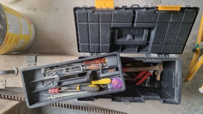 a tool box with tools in it sitting on the ground