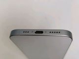 the back of a silver cell phone sitting on top of a white table