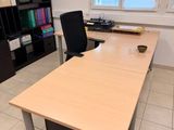 a desk with a chair and bookshelf in the corner