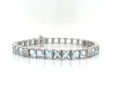 a close up of a diamond bracelet on a white surface