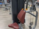 a gym room with machines and a plant in the middle of the room