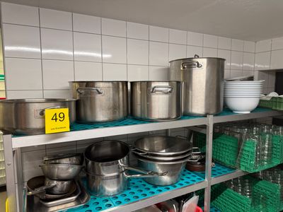 de nombreuses casseroles et poêles sur les étagères de la cuisine