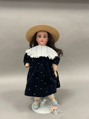 un gros plan d'une poupée portant un chapeau et une robe