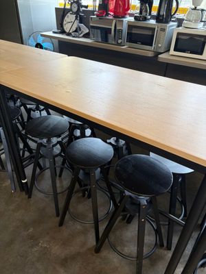 tables and stools are lined up in a room with a clock