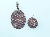 a close up of a pair of earrings on a white surface