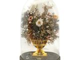 a glass dome with flowers inside of it on a table
