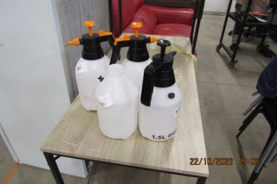 quatre bidons en plastique posés sur une table en bois