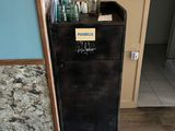 a small black refrigerator in the corner of a room