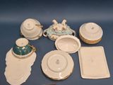 several pieces of porcelain sitting on top of a table next to a knife