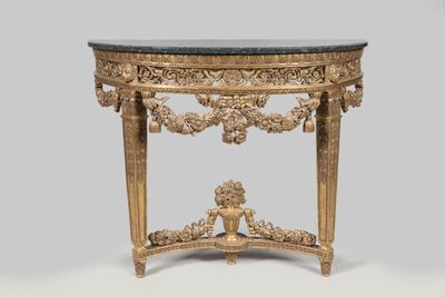 a gold console table with a black marble top