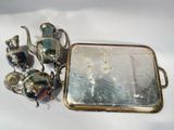 a silver tray with teapots and a mirror on it
