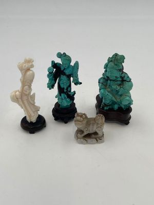 three figurines of a woman and a man on a white surface