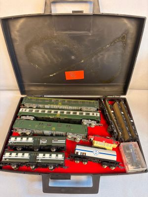 a suitcase with a train set in it on a white surface