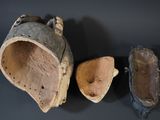 three pairs of old shoes are sitting on a black surface