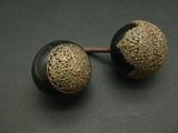 pair of black and gold metal knobs on a black surface