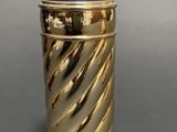 an image of a gold and blue container on a gray surface