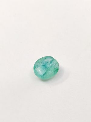 a green emerald stone on a white surface